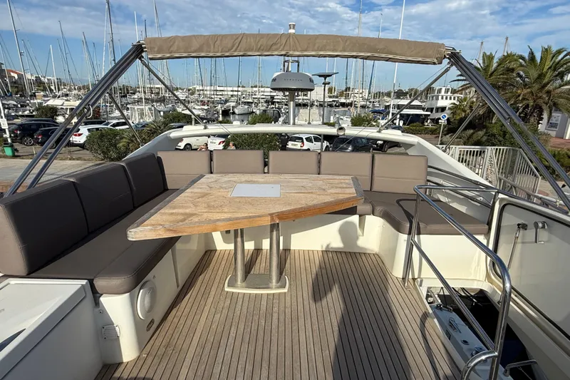  Yacht Photos Pics Prestige 560 Fly 2017 yacht flybridge with seating and table, docked at marina.