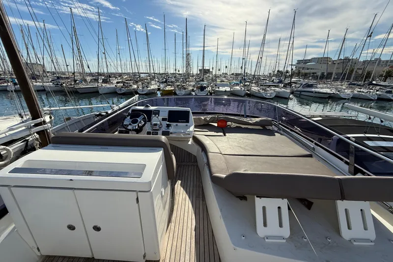  Yacht Photos Pics Flybridge of 2017 Prestige 560 Fly yacht in a marina, surrounded by sailboats.