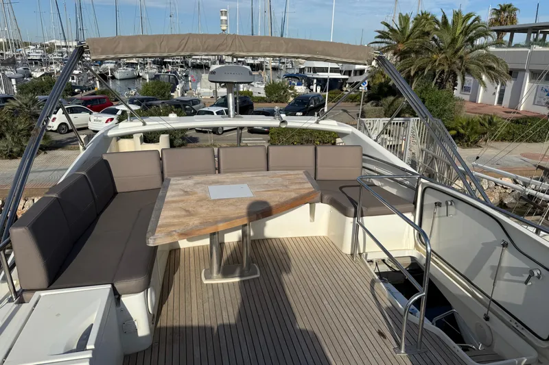  Yacht Photos Pics Flybridge seating area on a 2017 Prestige 560 Fly yacht, docked at a marina.