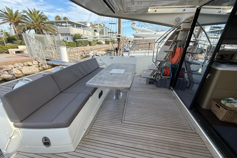  Yacht Photos Pics Luxurious 2017 Prestige 560 Fly yacht deck with seating and table, docked at marina.