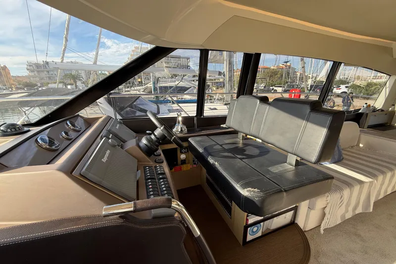  Yacht Photos Pics Interior view of 2017 Prestige 560 Fly yacht cockpit with leather seating and navigation controls.