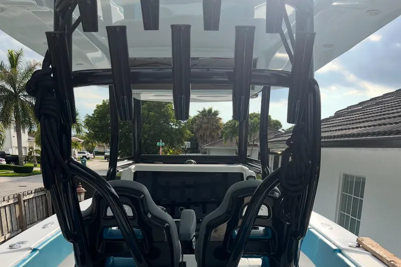 Yacht Photos Pics 2023 Sea Tech 33 CC boat interior with rod holders and seating, parked in a residential area.