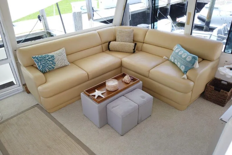Marlintini Yacht Photos Pics Luxurious beige seating area on 1999 Viking Cockpit Motoryacht with decorative pillows and ottomans.