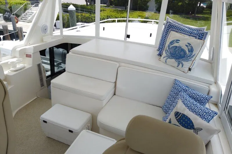 Marlintini Yacht Photos Pics 1999 Viking Cockpit Motoryacht interior with white seating and nautical-themed cushions.