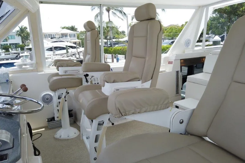 Marlintini Yacht Photos Pics 1999 Viking Cockpit Motoryacht interior with beige captain chairs and panoramic windows.