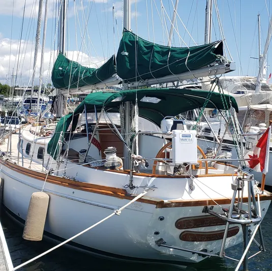 Isabella II Yacht Photos Pics 1988 Shannon 43 sailboat docked, featuring green covers and wooden accents.