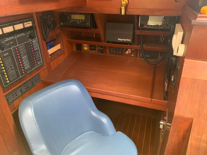 Isabella II Yacht Photos Pics Navigation station on 1988 Shannon 43 yacht with communication equipment and blue chair.