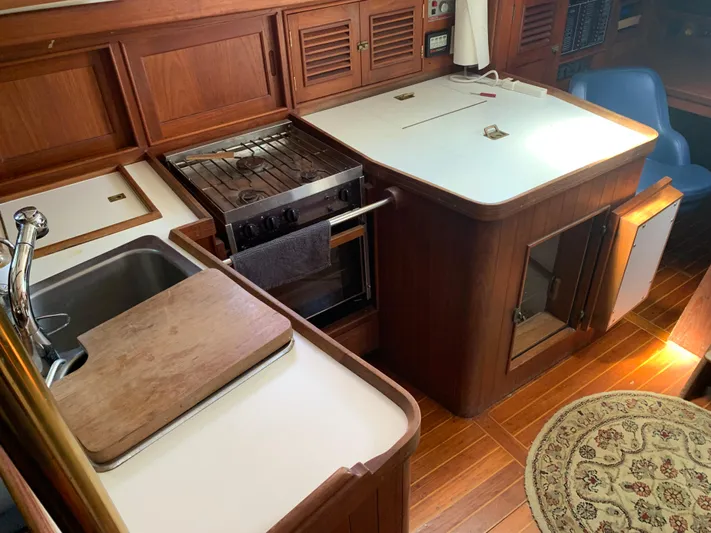 Isabella II Yacht Photos Pics 1988 Shannon 43 yacht interior kitchen with wood cabinetry, stove, sink, and countertop.