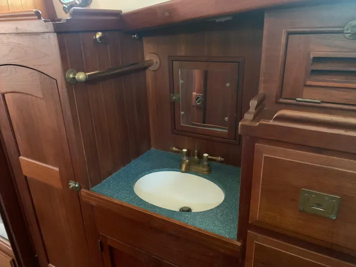 Isabella II Yacht Photos Pics Wooden bathroom vanity with brass fixtures on a 1988 Shannon 43 boat.