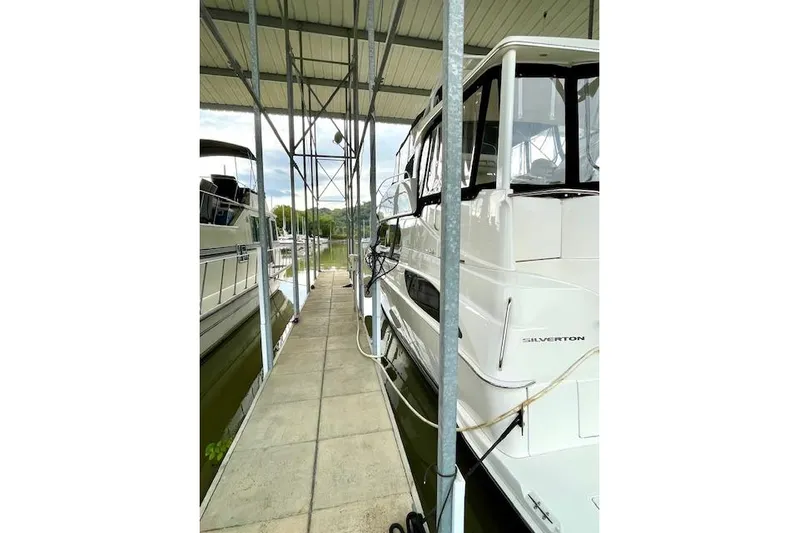 "sunseeker" Yacht Photos Pics 2002 Silverton 43 Motor Yacht docked under a covered marina.