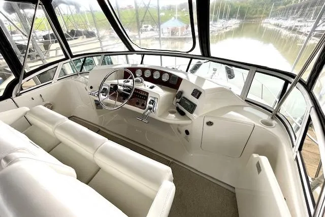 "sunseeker" Yacht Photos Pics Interior helm of 2002 Silverton 43 Motor Yacht with white seating and control panel.