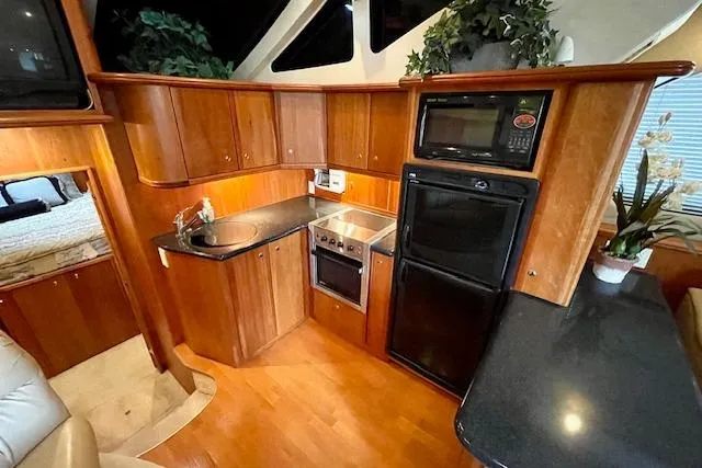 "sunseeker" Yacht Photos Pics Luxurious kitchen interior of 2002 Silverton 43 Motor Yacht with modern appliances and wood cabinetry.
