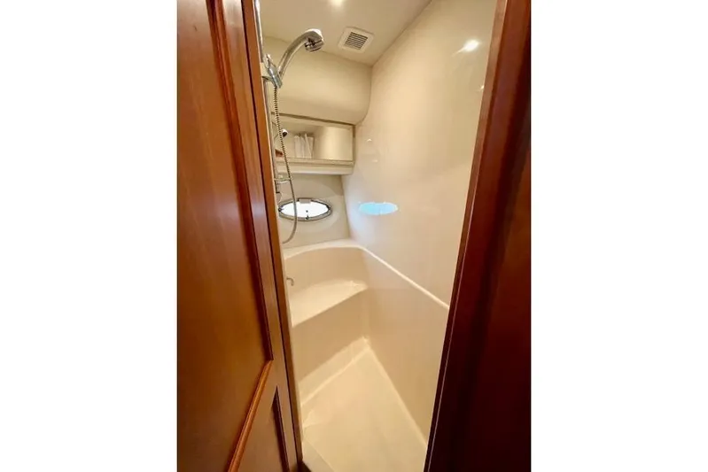 "sunseeker" Yacht Photos Pics Shower area in 2002 Silverton 43 Motor Yacht with wooden door and porthole window.