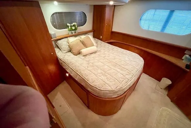 "sunseeker" Yacht Photos Pics Luxurious bedroom interior of 2002 Silverton 43 Motor Yacht with cozy bed and elegant wood finish.