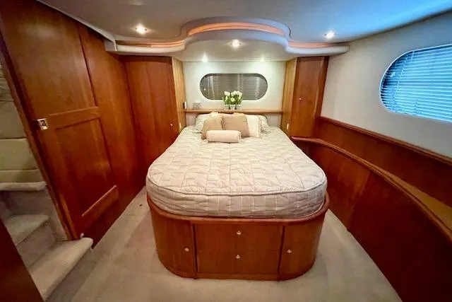 "sunseeker" Yacht Photos Pics Luxurious bedroom interior of 2002 Silverton 43 Motor Yacht with elegant wood paneling.