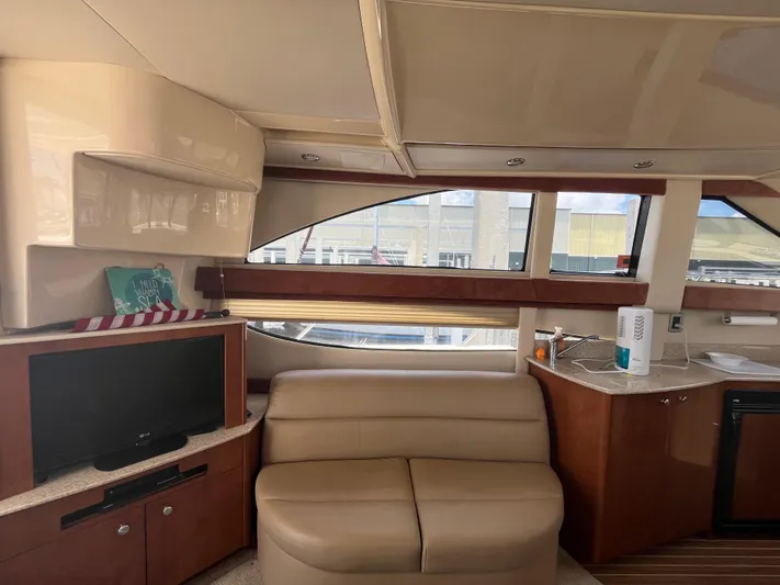 Compass Rose Yacht Photos Pics Interior of 2006 Meridian 341 Sedan yacht with sofa, TV, and kitchenette.
