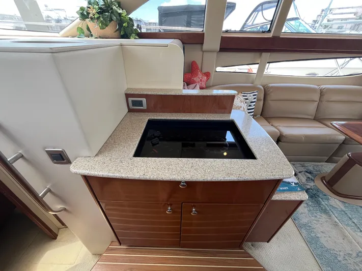 Compass Rose Yacht Photos Pics Luxurious interior of a 2006 Meridian 341 Sedan yacht with modern kitchenette and seating area.