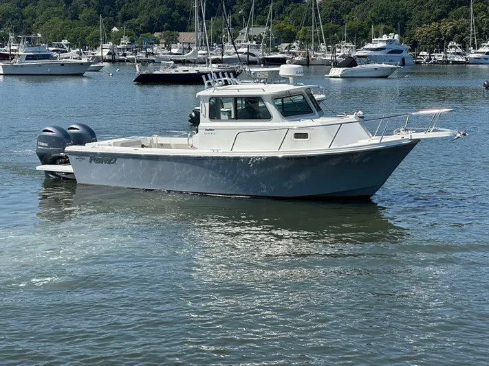  Yacht Photos Pics 2022 Parker 2520 XLD Sport Cabin boat on calm water, surrounded by other vessels.