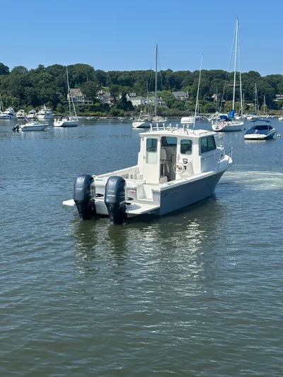  Yacht Photos Pics 2022 Parker 2520 XLD Sport Cabin boat on a calm lake with other boats.