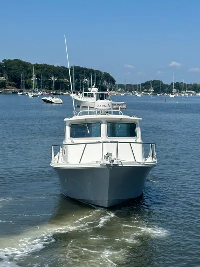  Yacht Photos Pics 2022 Parker 2520 XLD Sport Cabin boat on calm water, with marina background.