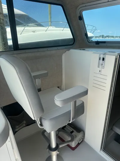  Yacht Photos Pics Interior of 2022 Parker 2520 XLD Sport Cabin with a cushioned seat and window view.