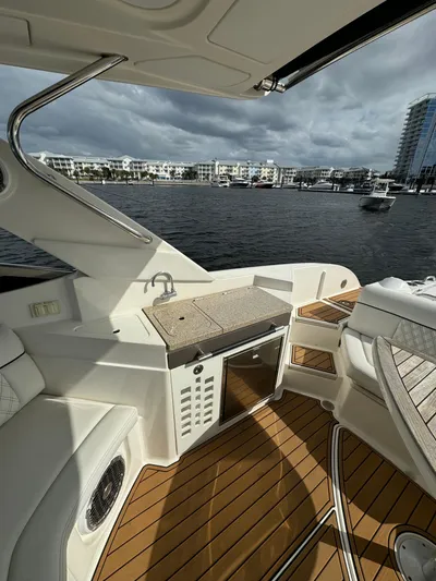  Yacht Photos Pics 2015 Sea Ray 350 SLX boat interior with waterfront view, featuring seating and kitchenette.