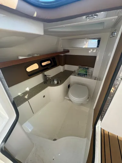  Yacht Photos Pics Interior of 2015 Sea Ray 350 SLX boat, featuring a compact bathroom with sink and toilet.