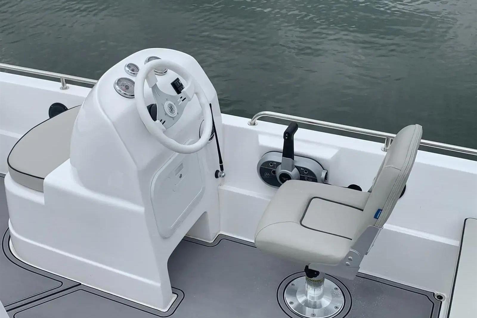 2022 Hunky Dory boat cockpit with steering wheel and seat, on calm water.