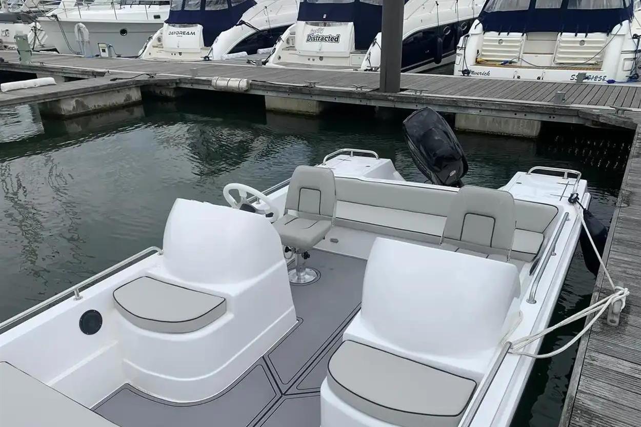 2022 Hunky Dory boat docked at marina, featuring sleek white design and comfortable seating.