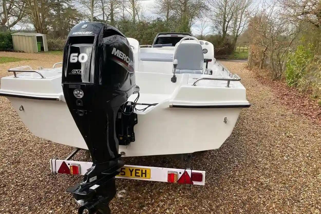 2022 Hunky Dory boat with Mercury 60 engine on gravel driveway.