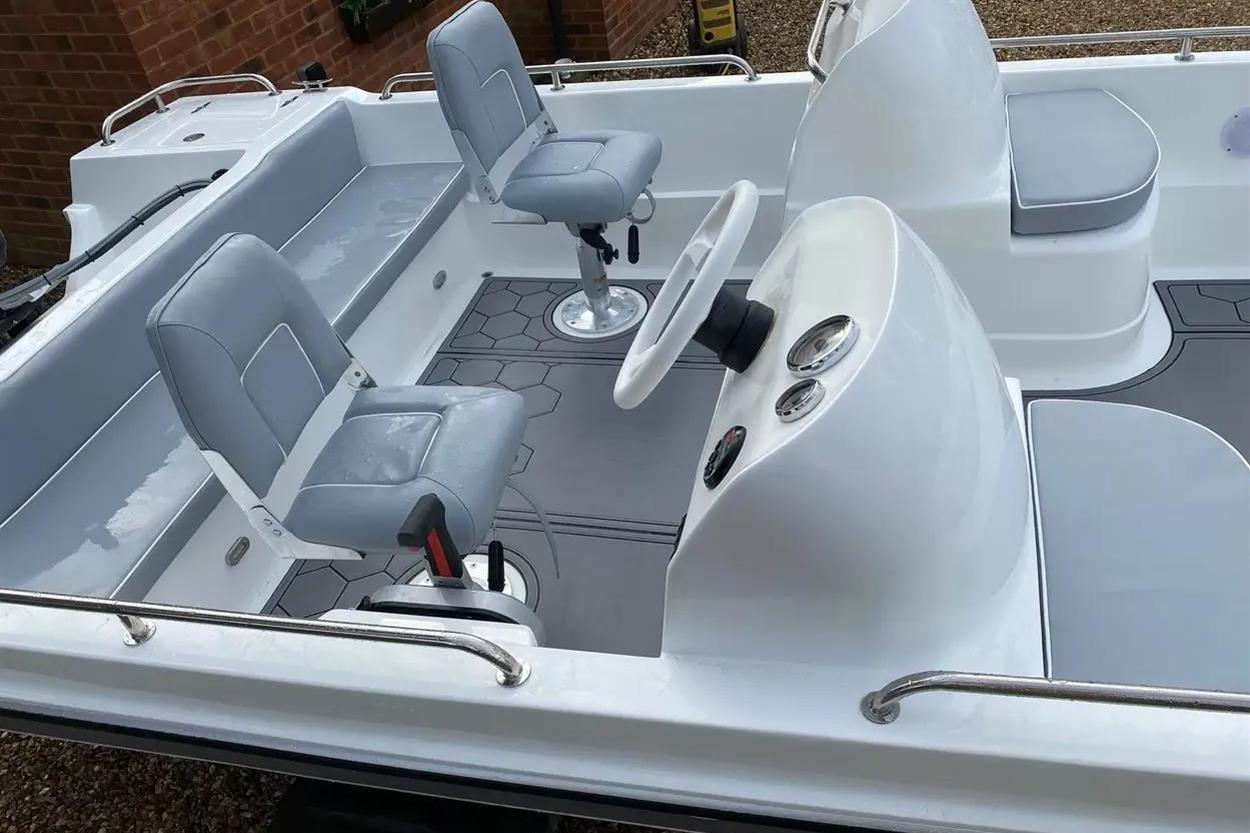 2022 Hunky Dory boat interior with gray seating and steering console.