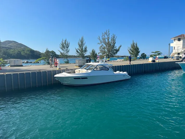  Yacht Photos Pics 2020 Pursuit DC 365 Dual Console boat docked in a scenic marina.