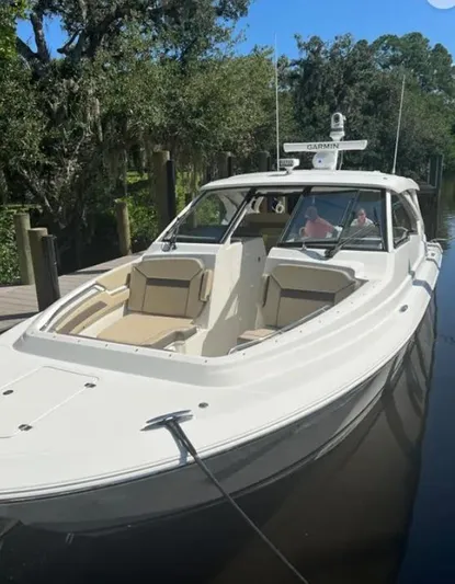  Yacht Photos Pics 2020 Pursuit DC 365 Dual Console boat docked on a calm waterway.