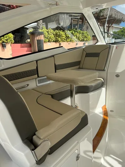  Yacht Photos Pics 2020 Pursuit DC 365 Dual Console boat interior with beige seating and table.