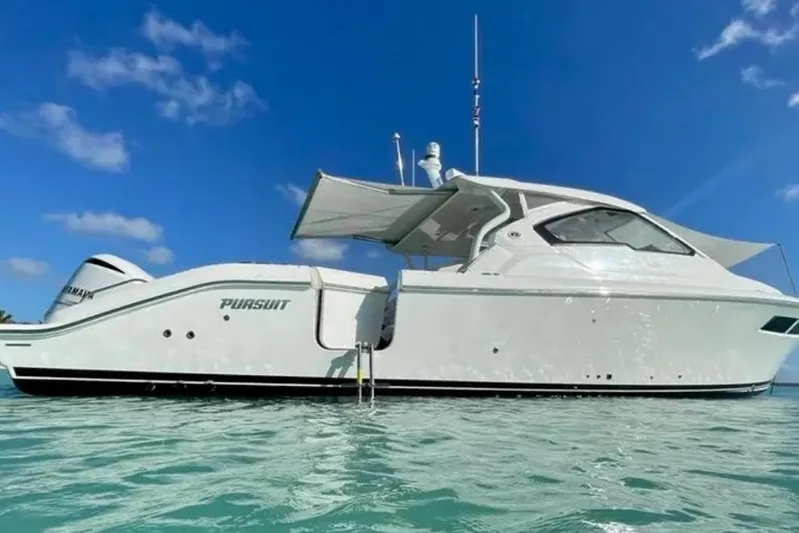  Yacht Photos Pics 2020 Pursuit DC 365 Dual Console boat on clear blue water under a sunny sky.
