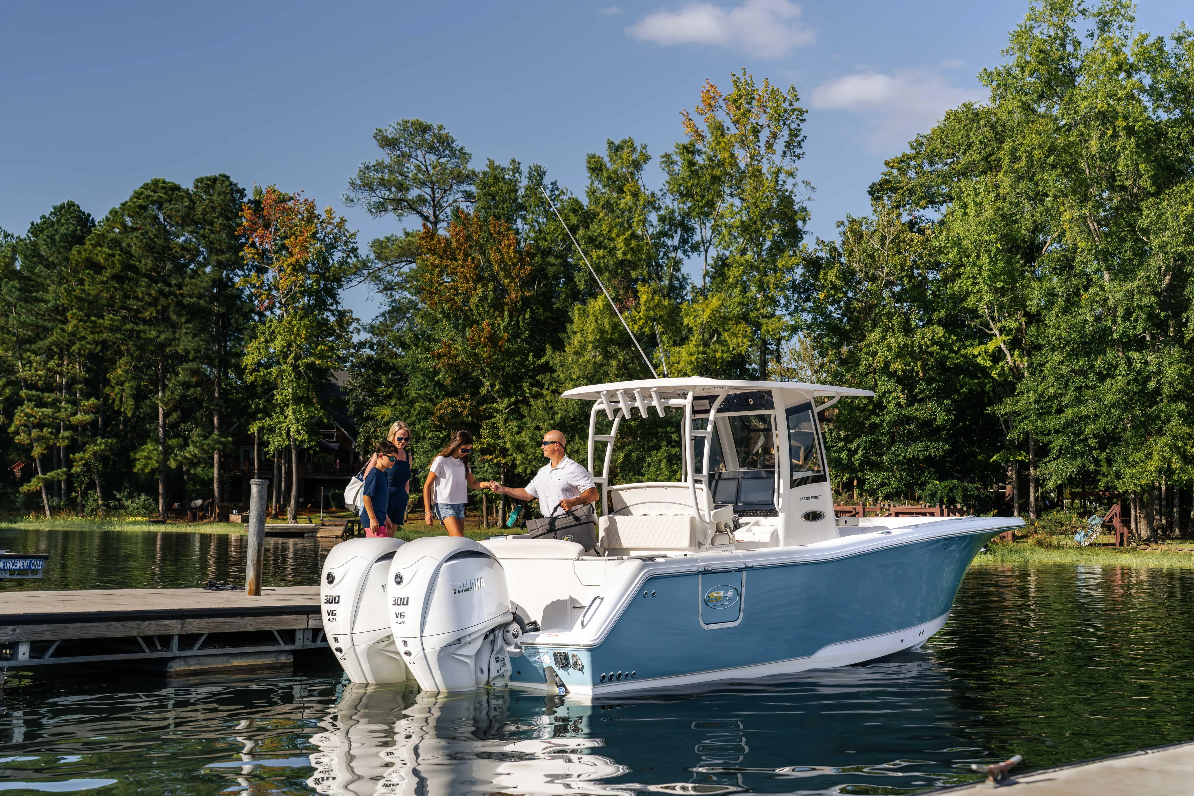  Yacht Photos Pics 2026 Sea Hunt Ultra 285 Coffin Box boat docked on a serene lake with people boarding.