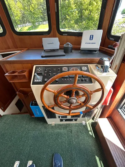 Forget Me Knot Yacht Photos Pics 2001 Nordic Tug 32 helm with wooden wheel, Garmin and Furuno navigation systems.