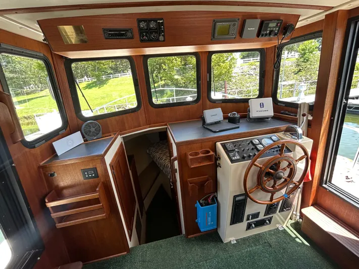 Forget Me Knot Yacht Photos Pics Cabin interior of a 2001 Nordic Tug 32 with wooden helm and navigation equipment.