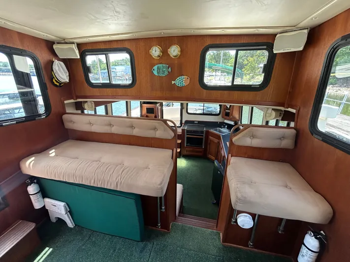 Forget Me Knot Yacht Photos Pics Interior of 2001 Nordic Tug 32 with cushioned seating and wooden accents.