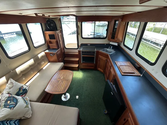 Forget Me Knot Yacht Photos Pics Interior of 2001 Nordic Tug 32 with cozy seating, kitchen, and large windows.