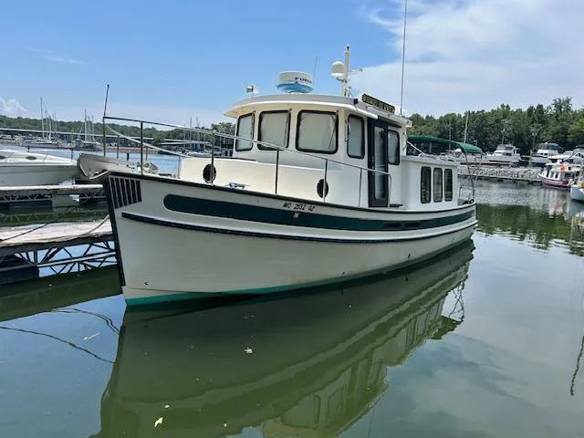 Forget Me Knot Yacht Photos Pics 2001 Nordic Tug 32 boat docked in a marina on a sunny day.