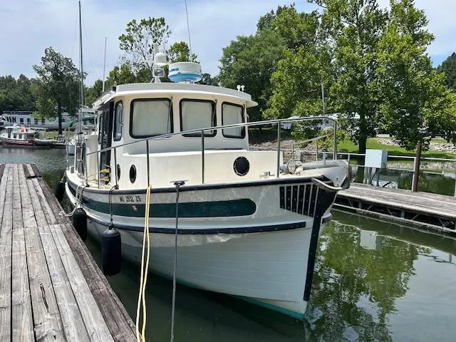 Forget Me Knot Yacht Photos Pics 2001 Nordic Tug 32 docked in a serene marina setting.