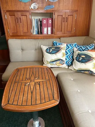 Forget Me Knot Yacht Photos Pics Cozy Nordic Tug 32 interior with wooden table, cushioned seating, and decorative pillows.