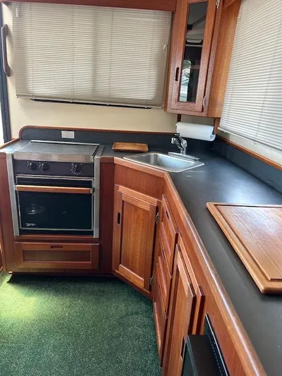 Forget Me Knot Yacht Photos Pics Interior of 2001 Nordic Tug 32 kitchen with wood cabinetry and appliances.