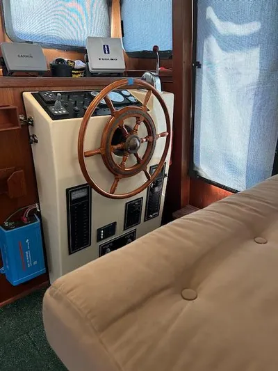 Forget Me Knot Yacht Photos Pics Interior helm of a 2001 Nordic Tug 32 with wooden steering wheel and navigation equipment.