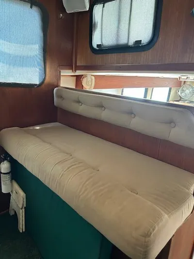 Forget Me Knot Yacht Photos Pics Interior of 2001 Nordic Tug 32 with cushioned seating and wooden paneling.