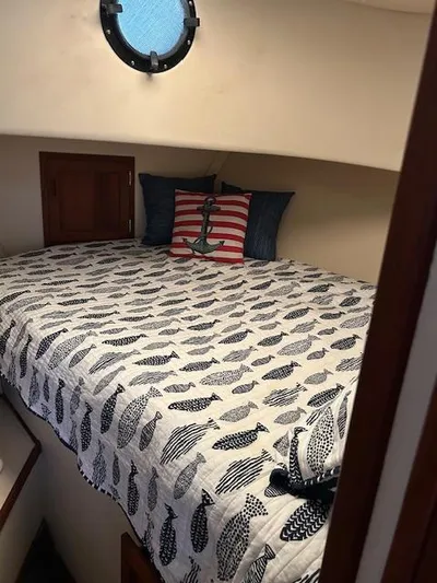 Forget Me Knot Yacht Photos Pics Cozy cabin bed in 2001 Nordic Tug 32 with nautical-themed bedding and porthole window.