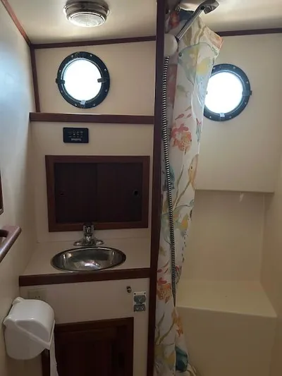 Forget Me Knot Yacht Photos Pics Nordic Tug 32 bathroom with sink, shower, and porthole windows, 2001 model.