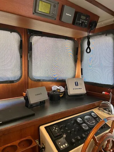 Forget Me Knot Yacht Photos Pics Control panel of a 2001 Nordic Tug 32 with navigation equipment and steering wheel.