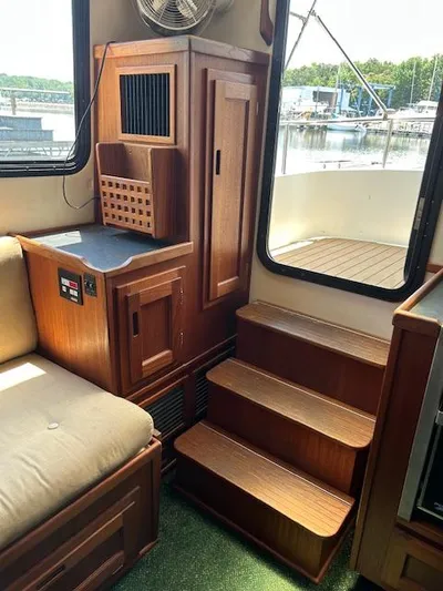 Forget Me Knot Yacht Photos Pics Interior of 2001 Nordic Tug 32, featuring wooden cabinetry and steps leading to deck.